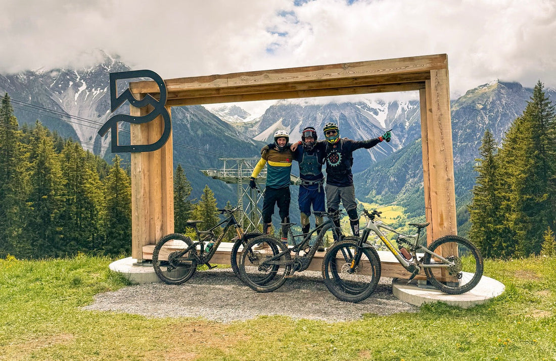 Drei Mountainbiker am Bikepark Brandnertal Eingangsschild mit Blick ins Tal